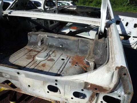 2001 Ford Crown Victoria - The interior of a car's trunk is visible, showing significant rust and missing components.