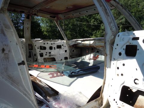 2001 Ford Crown Victoria - The interior of a car stripped down to its bare metal frame, with the windshield and dashboard structure visible.