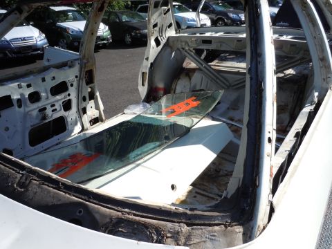 2001 Ford Crown Victoria - The interior of a dismantled vehicle shows exposed metal and a detached windshield with orange markings.
