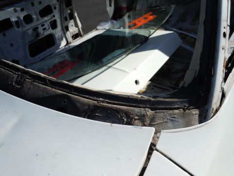 2001 Ford Crown Victoria - The interior of a vehicle stripped down to its frame, with a broken windshield visible.