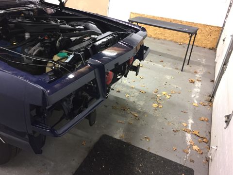 2001 Ford Crown Victoria - Car in garage with front bumper removed, engine exposed for work.