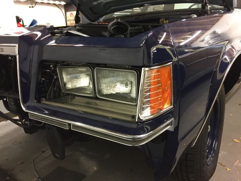 2001 Ford Crown Victoria - The front clip of a dark blue sedan is shown with the hood up, revealing the engine bay.