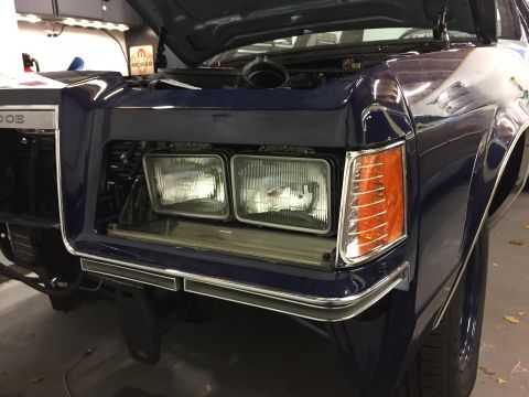 2001 Ford Crown Victoria - The front of a dark blue car is shown with its hood open, revealing the engine bay.