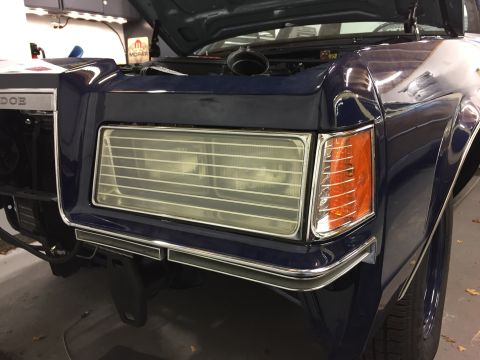 2001 Ford Crown Victoria - Close-up of the front of a dark blue vehicle, showing its distinctive grille and headlight assembly.