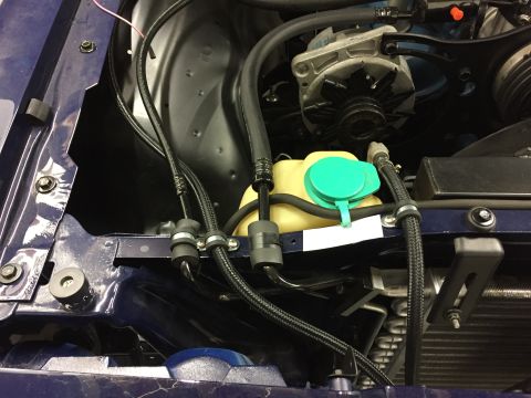 2001 Ford Crown Victoria - Close-up view of an engine bay, highlighting the alternator and windshield washer fluid reservoir with its green cap.