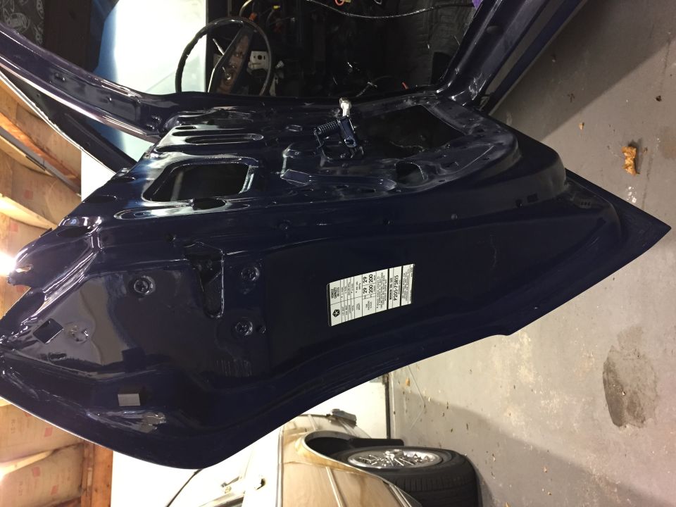 Car door jamb with VIN sticker visible. Shows interior of a dark blue vehicle