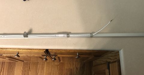 1995 Ford Bronco - A fluorescent light fixture is mounted to the ceiling, with a white wire extending from it. The Supermotors.net logo is visible in the lowe…