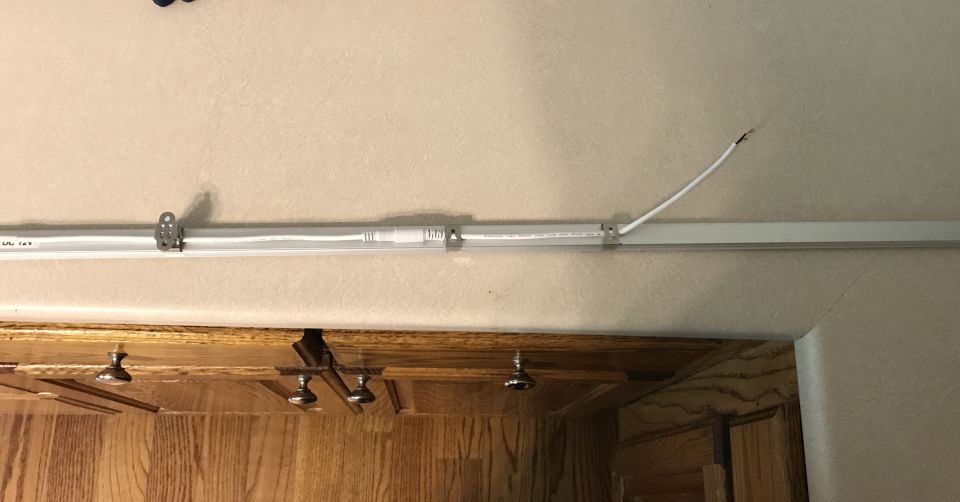 Fluorescent light fixture with exposed wire and Supermotors.net logo