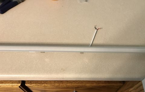1995 Ford Bronco - Exposed electrical wires emerge from a light fixture installed on a textured ceiling surface.