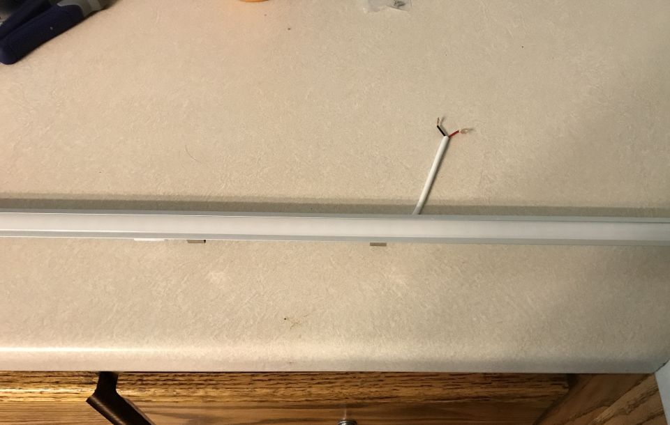exposed wires coming out of a ceiling fixture above a countertop