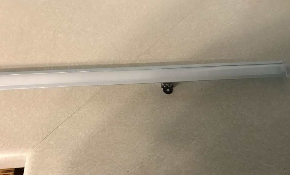 metal trim piece with a mounting bracket attached to a textured wall