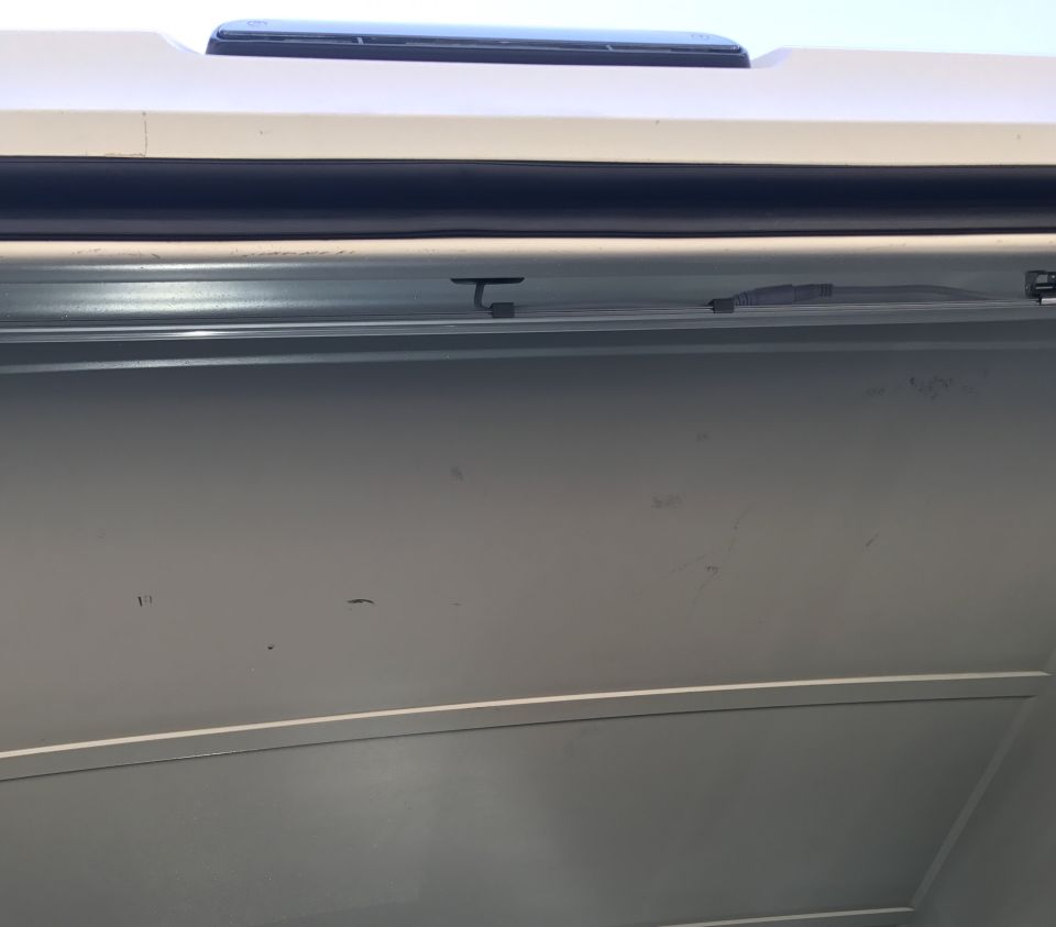 Close-up of a vehicle's interior roofline and upper door panel, showing a sunroof and trim