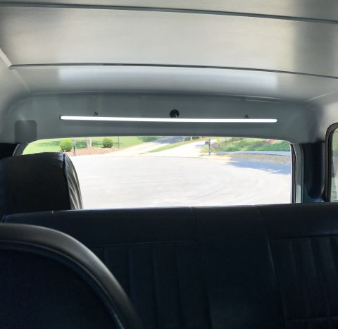 1995 Ford Bronco - Looking out the rear window of a vehicle, showing a suburban street scene.