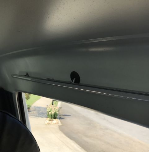 1995 Ford Bronco - Interior shot looking out a window, showing the headliner and a glimpse of the exterior.