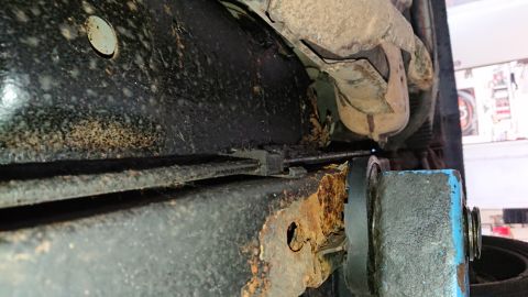1999 Ford Fairlane - Close-up of heavily rusted vehicle undercarriage, showing structural damage and wear.