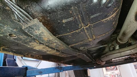 1999 Ford Fairlane - The underside of a vehicle displays significant rust, indicating potential structural issues.