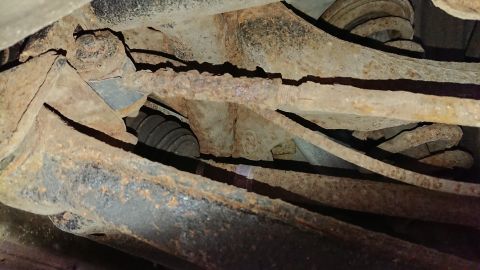 1999 Ford Fairlane - Heavily rusted suspension components are visible on the underside of a vehicle.