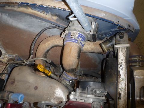 1969 MINI Cooper - Close-up view of engine components, including rusted pipes and blue hose clamps, with visible text from SuperMotors.net.