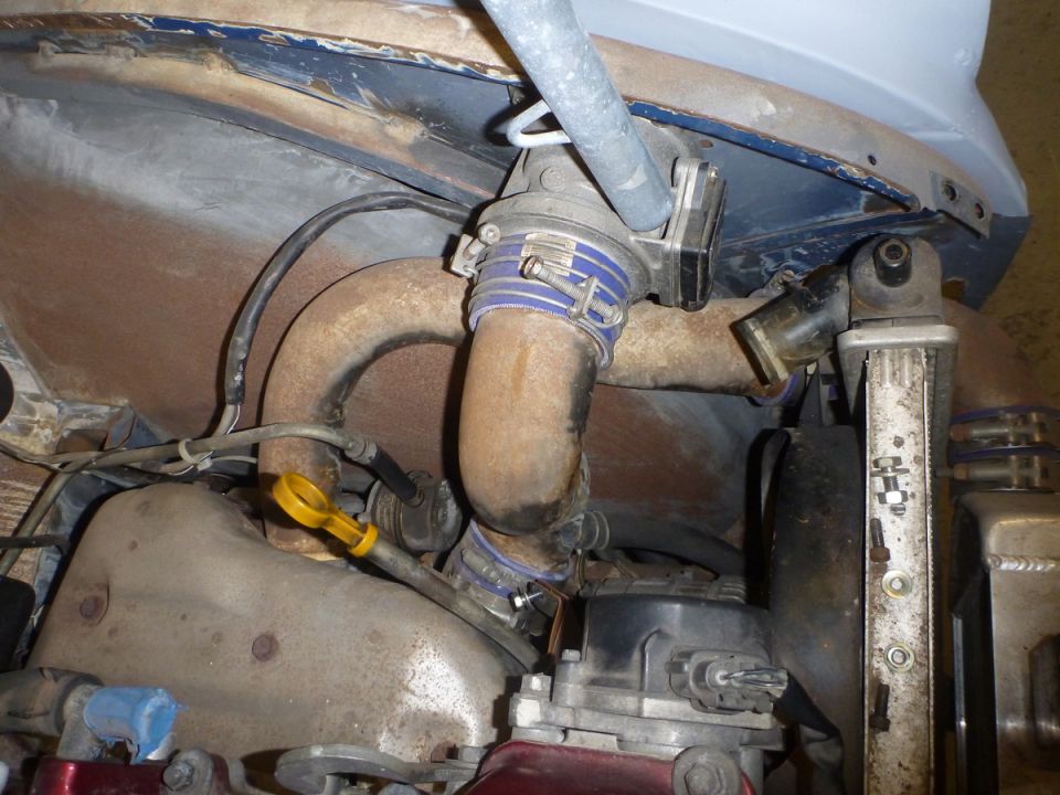 Engine bay detail with rusted pipes and blue hose clamps