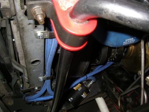 1994 Ford Bronco - Close-up view of engine bay components including blue braided hoses and a black filter.