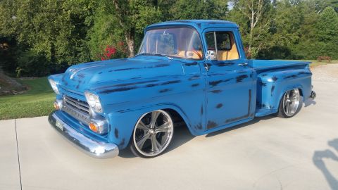 1980 Pontiac Trans Am - This vintage pickup truck features a worn blue paint job and modern chrome wheels.