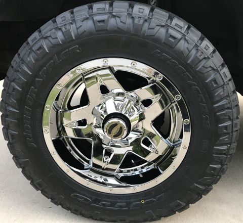 1995 Ford Bronco - A close-up view of a chrome wheel and tire assembly, a "Road Grappler" tire.