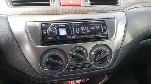 2006 Mitsubishi Evolution - Close-up of a car's dashboard, showing the center console with an aftermarket stereo and HVAC controls.