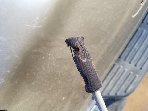 1978 Ford Bronco - Close-up of a damaged rubber handle attached to a metal rod, likely a vehicle part.