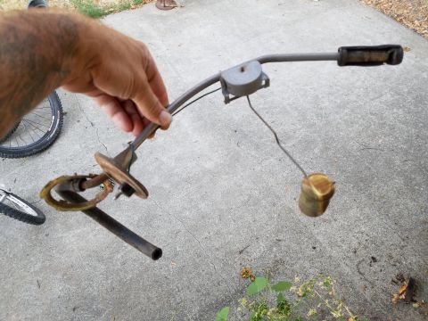 1978 Ford Bronco - A person holds a fuel sending unit, likely removed from a vehicle for repair or replacement.