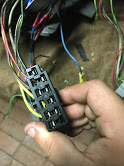 1988 Ford Bronco - Close-up of a hand holding an electrical connector with many wires, likely part of a vehicle's wiring system.