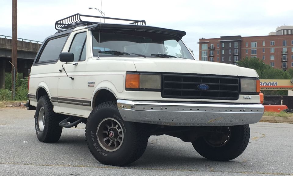 White 1988 Ford Bronco with roof rack, 3/4 front view
