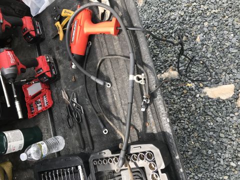 1992 Ford Bronco - Tools and battery cables are organized in the bed of a truck, ready for use.