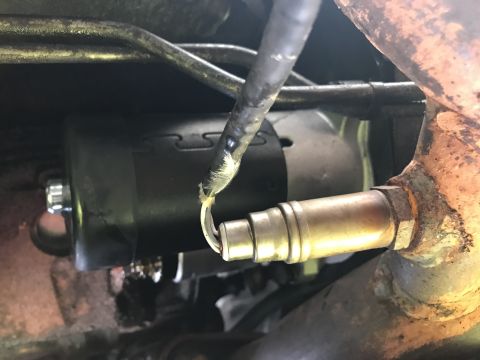 1992 Ford Bronco - Close-up view of an oxygen sensor and starter motor, likely from a vehicle's exhaust system.