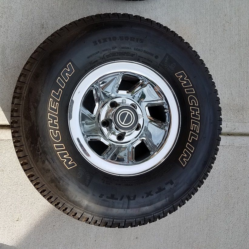 Ford Bronco wheel with Michelin LTX A/T tire. Chrome rim has 5 spokes and a circular center cap