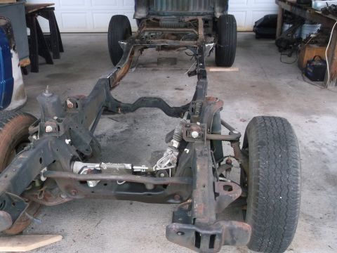 1999 Ford Ranger - The bare chassis of a truck is visible, with its front suspension and wheels intact.