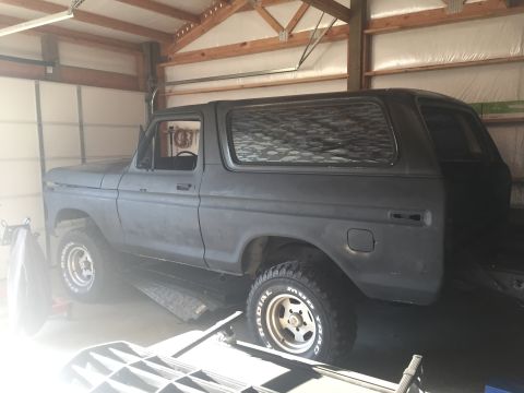 1978 Ford Bronco - A gray 1978 Ford Bronco sits in a garage, its matte paint reflecting the overhead light.