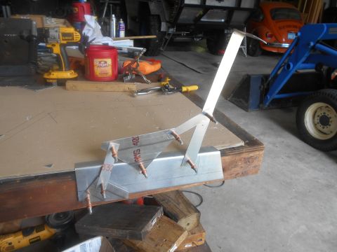 1992 Ford Bronco - A metal jig is set up on a workbench, with tools and other vehicles visible in the background.