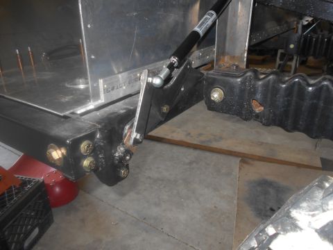 1992 Ford Bronco - Close-up view of a vehicle frame component a gas strut and bolted connections.