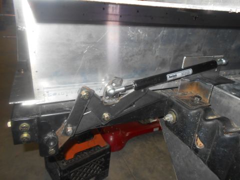1992 Ford Bronco - A close-up view shows a linkage mechanism and a shock absorber attached to a vehicle's frame.
