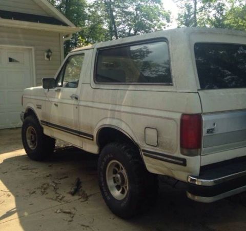 1988 Ford Bronco - This 1988 Ford Bronco is seen from the rear three-quarter angle, parked outside a residential garage.