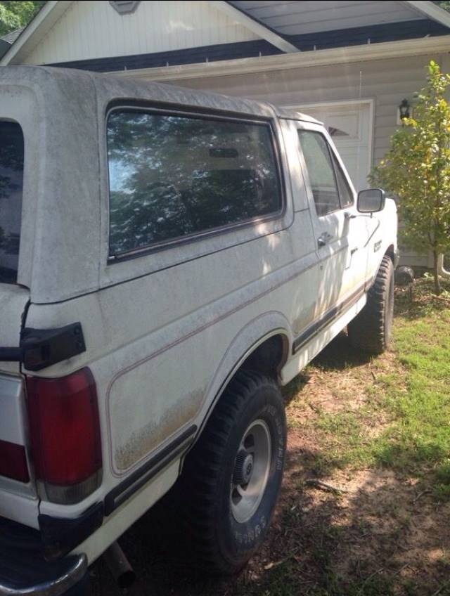 White Ford Bronco parked next to a house