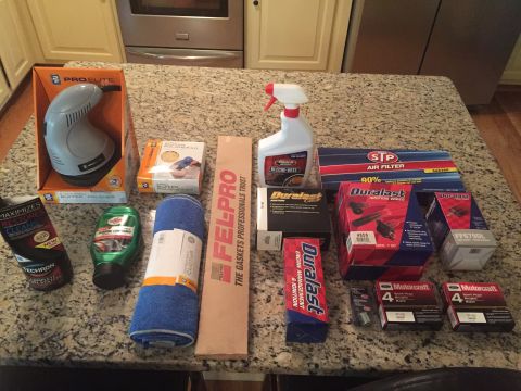 1988 Ford Bronco - Various automotive parts and cleaning products are arranged on a granite countertop, ready for use.