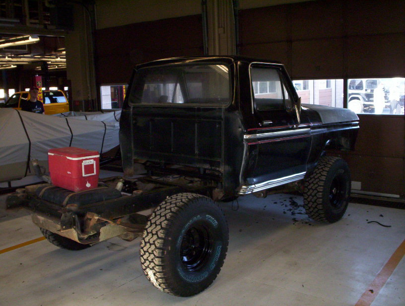 Black pickup truck chassis with red cooler, side view