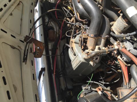 1988 Ford Bronco - Close-up view of the engine compartment, showing various hoses, wires, and mechanical parts.