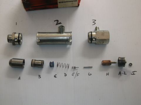 1979 Ford Ranchero - Various parts of a brake master cylinder are laid out and labeled for identification.