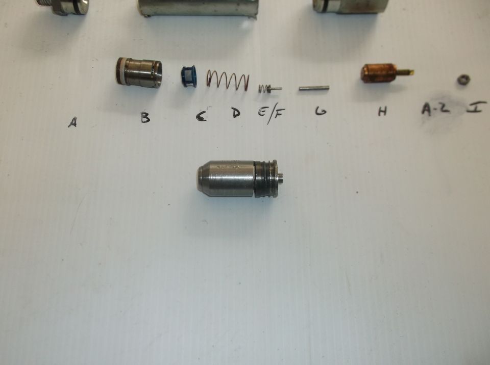 Disassembled carburetor components labeled A through I, with a main assembly shown below