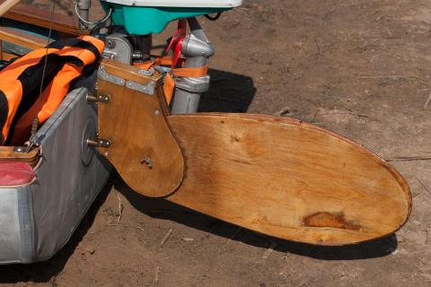 1993 Ford Bronco - A wooden rudder is attached to the stern of a small watercraft, likely a canoe or kayak, with a small outboard motor visible behind it. The…