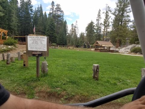 1968 Ford Bronco - A sign for Rubicon Soda Springs is visible in a grassy area with trees in the background. The sign details the fee schedule for overnight s…