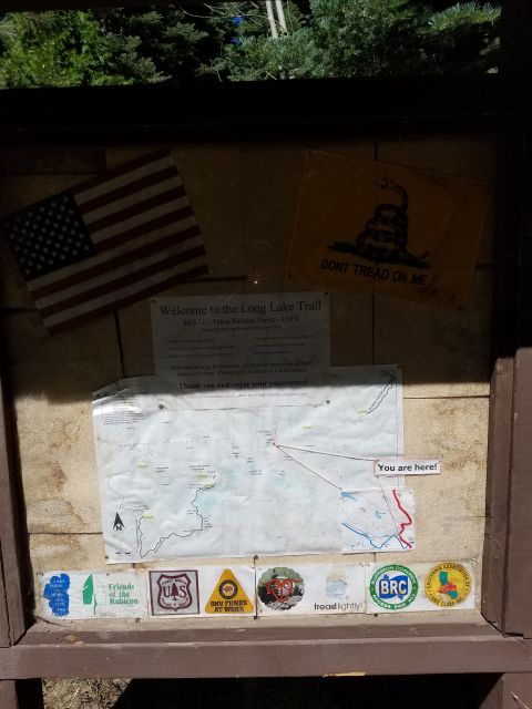 1968 Ford Bronco - A trail information display features maps, an American flag, and a Gadsden flag, along with various stickers and a welcome sign.