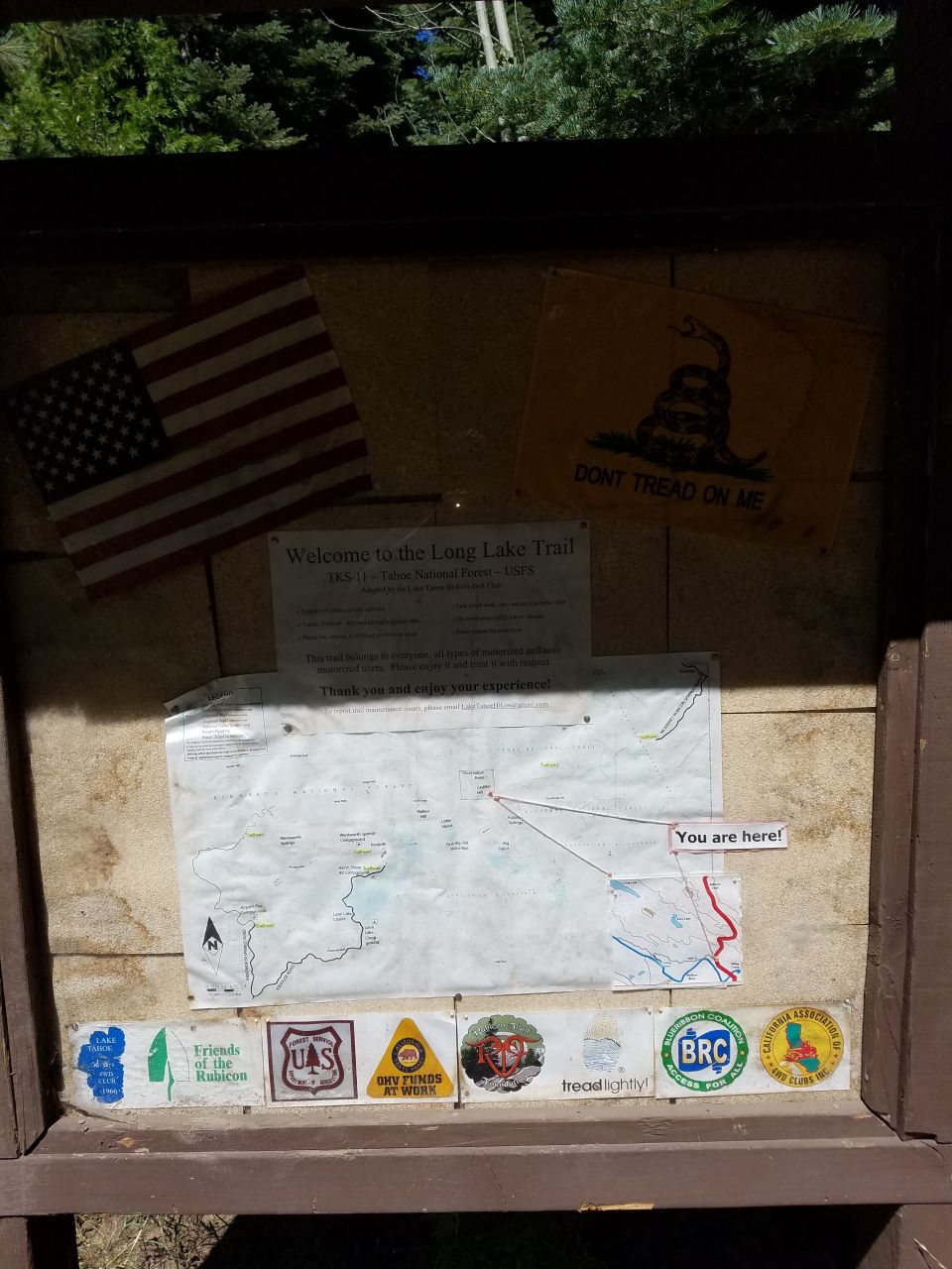 Trail information display with maps, American flag, and Gadsden flag